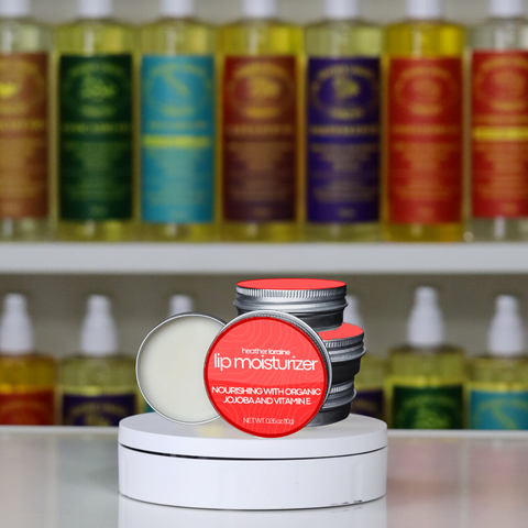 Lip moisturizer with red cap on a white pedestal in front of shelves with various bottles.